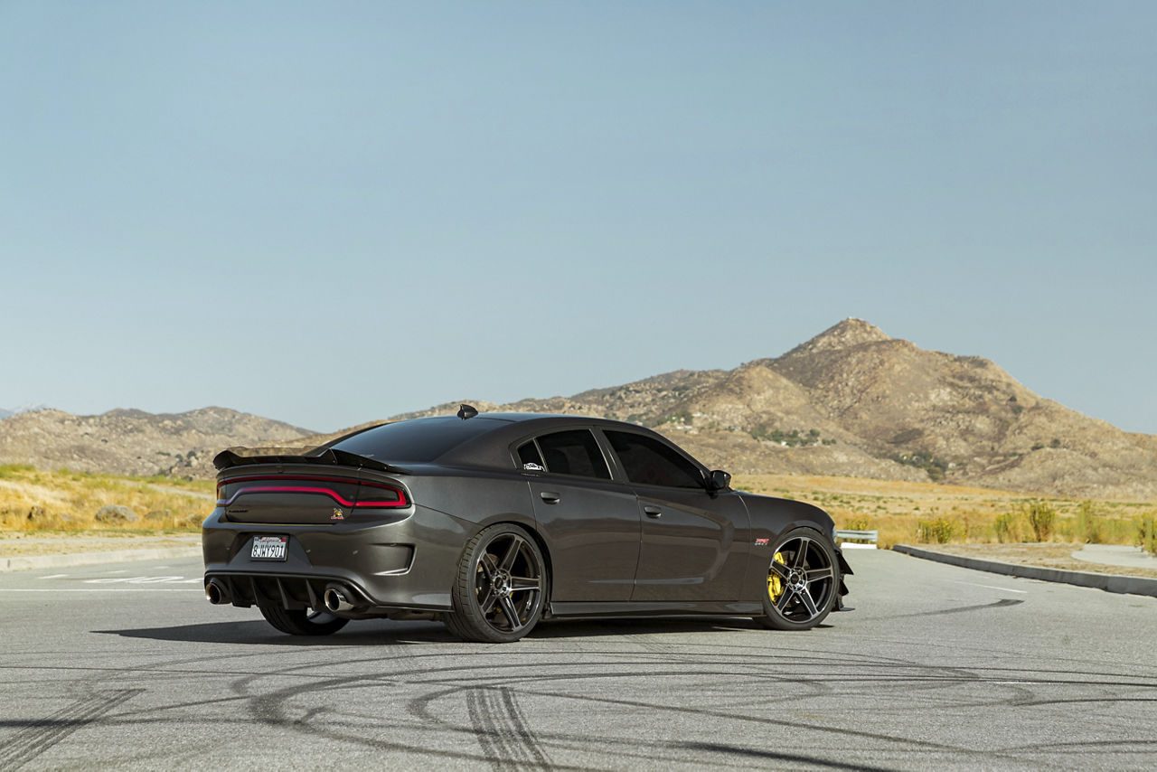 Gray Dodge Charger, rear three-quarter view, parked on a desert road with mountains behind it