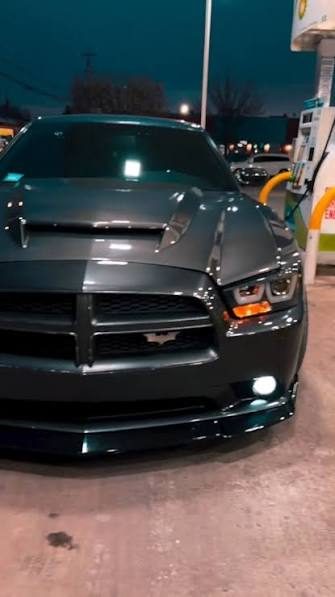 Blacked-out Dodge Charger, front view, parked at a gas station at night