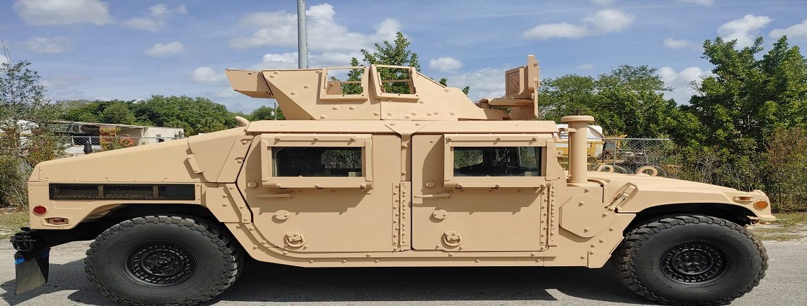 Tan HMMWV build with raised turret hatch and armored door panels